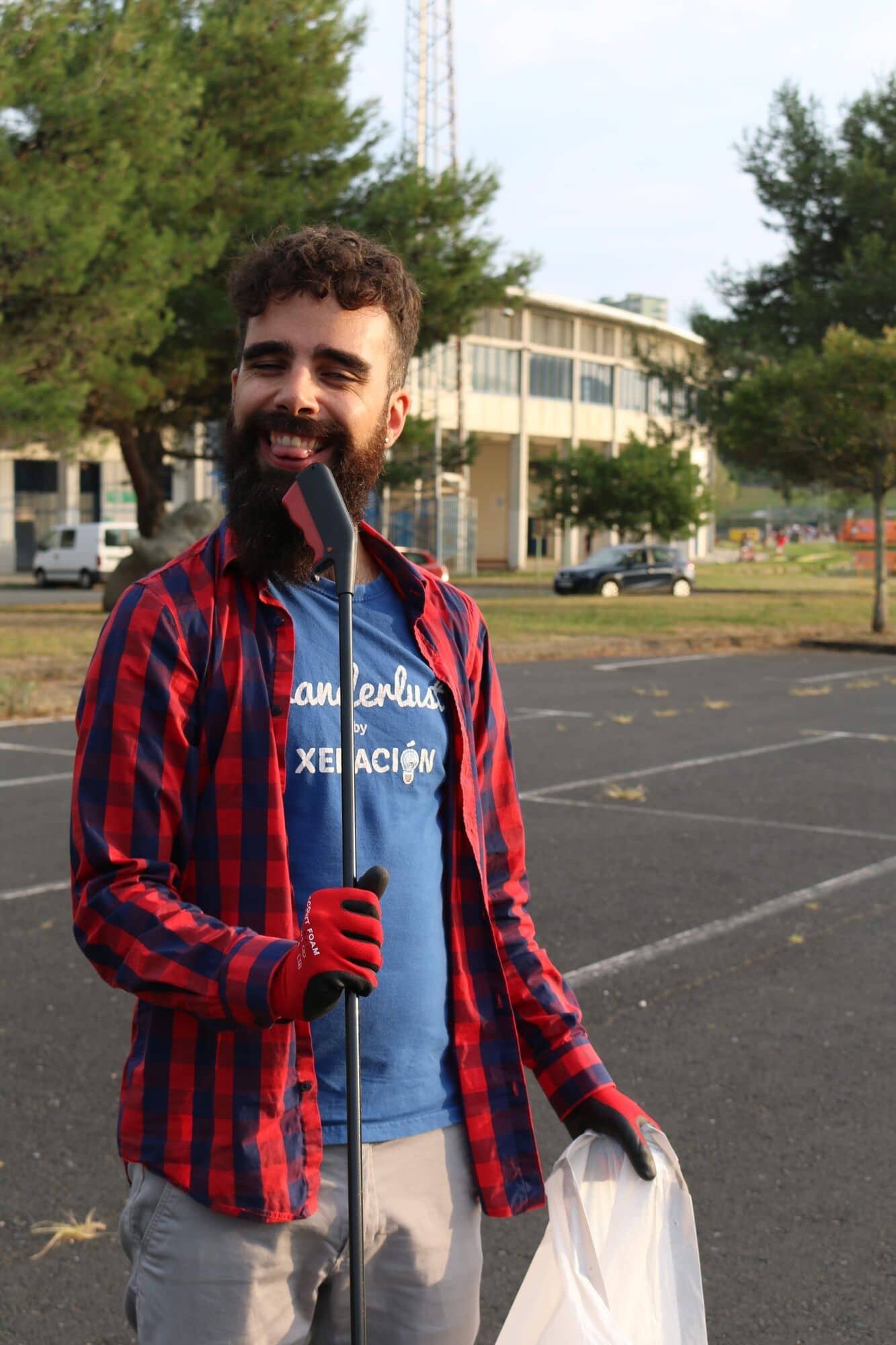 Voluntario sonriente con camisa de cuadros sosteniendo una bolsa